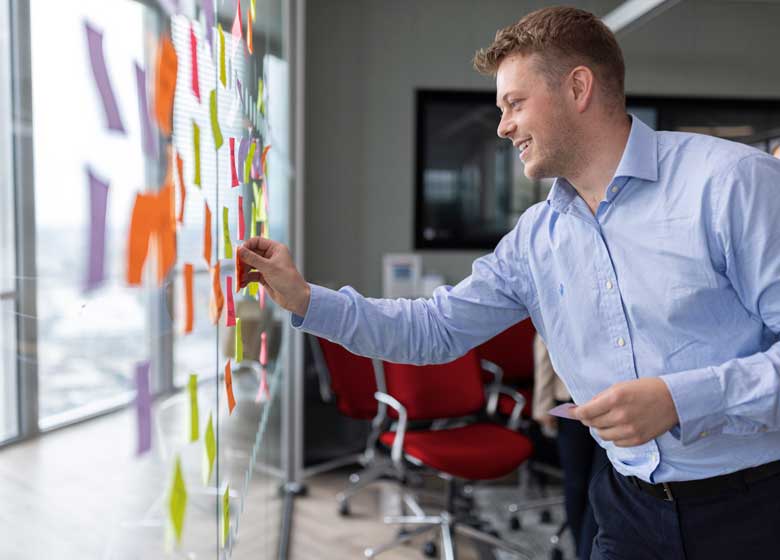 A group of employees brainstorm with notes