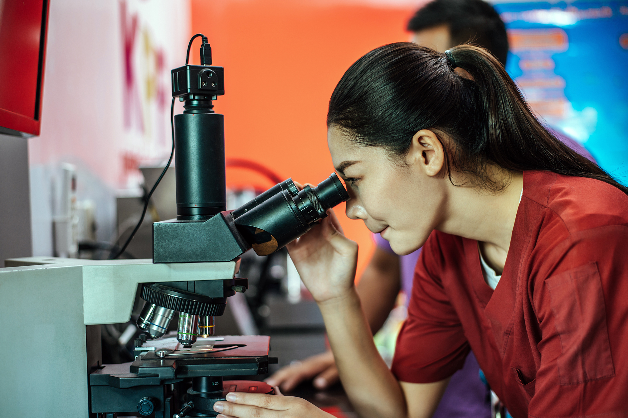 Woman looking through microscope