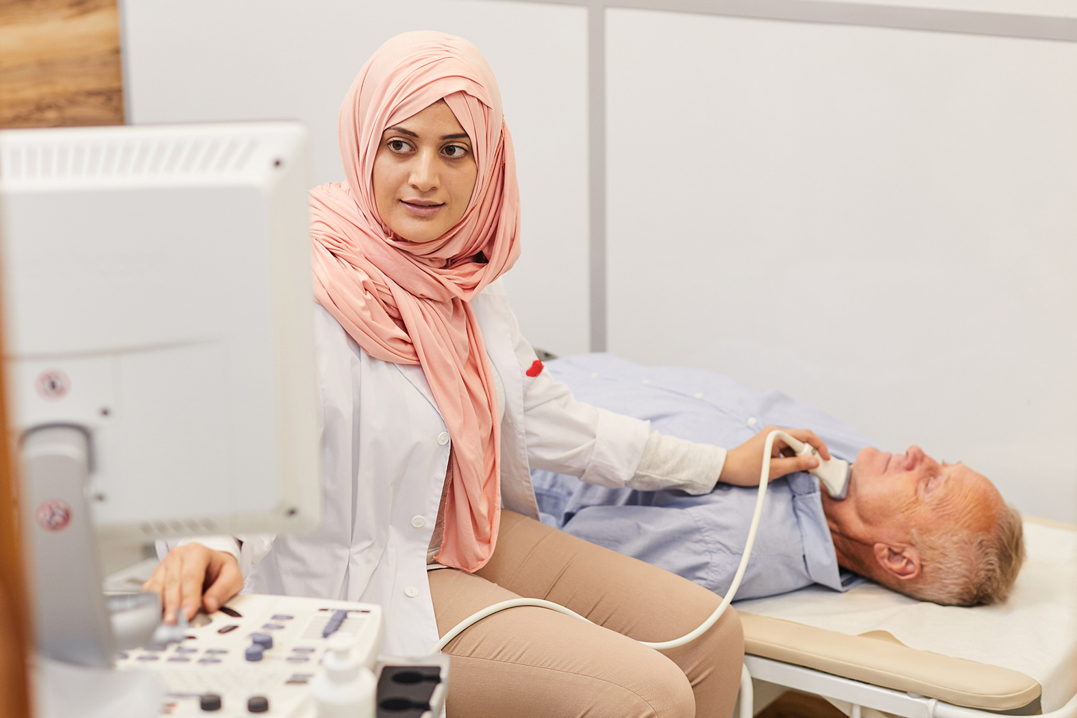 Doctor giving man a throat scan.