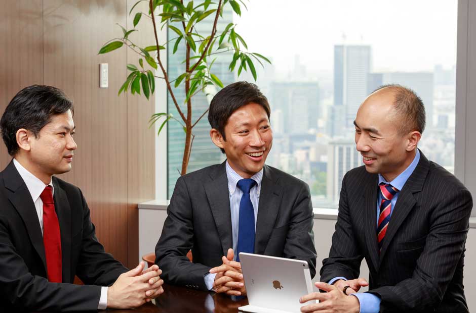 A trio of colleagues at RGA Japan meet around an ipad