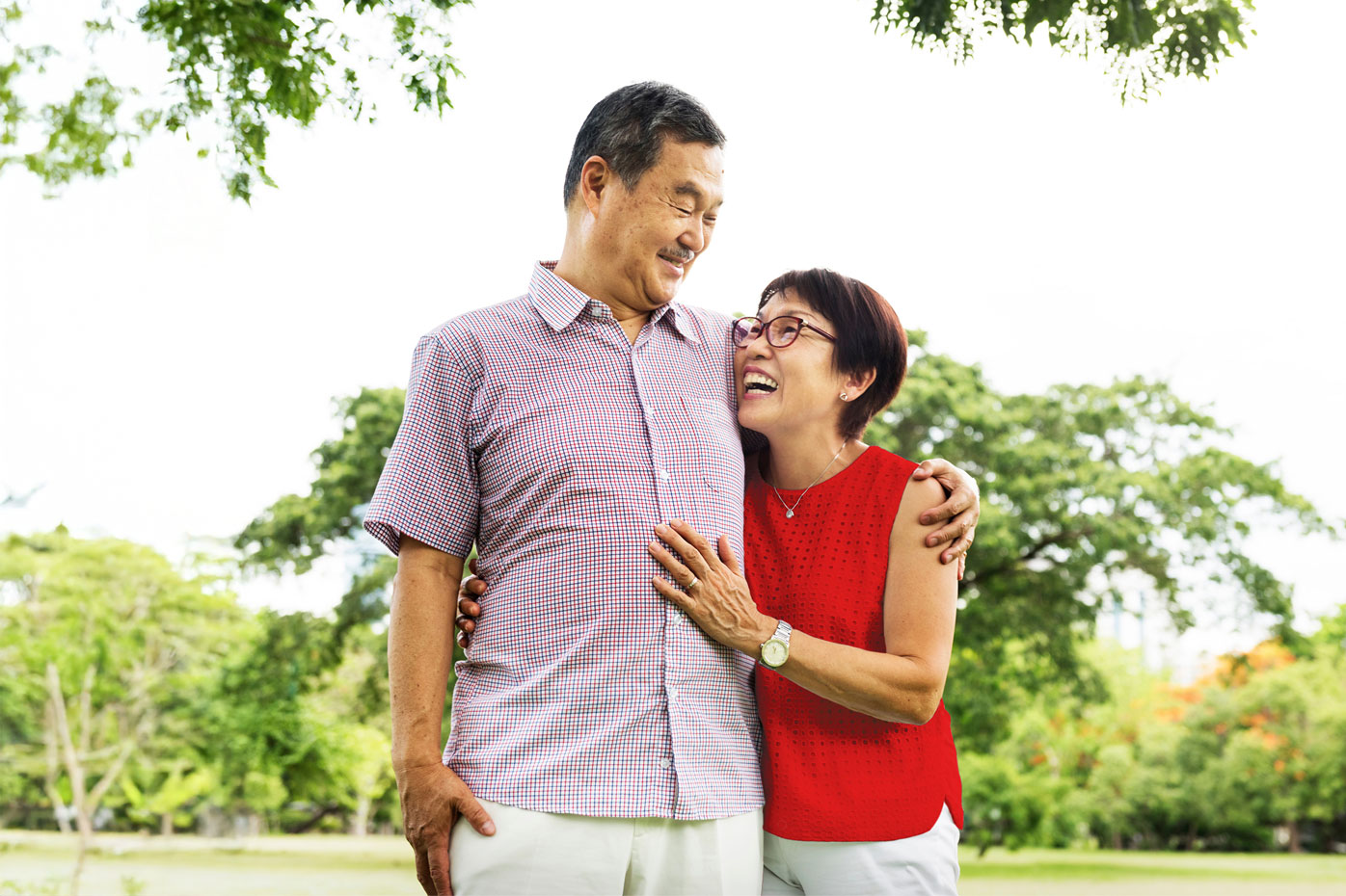 And older couple embraces in a park