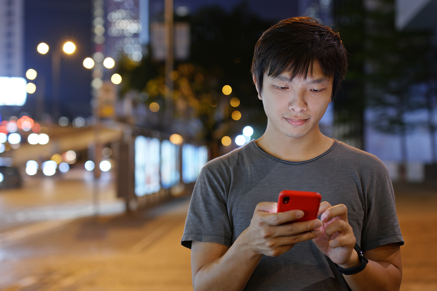 Man on a red phone in a city