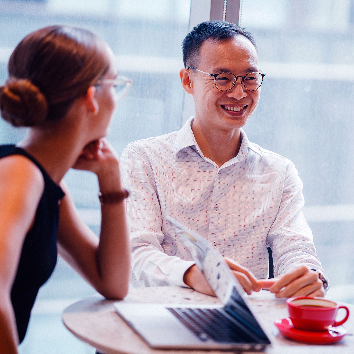 Man smiling while woman on computer.