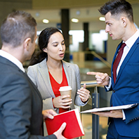 Two men and one woman standing and talking