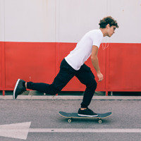 A male skateboarder travels on a skateboard