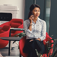 Woman talking on the phone while sitting in a red chair